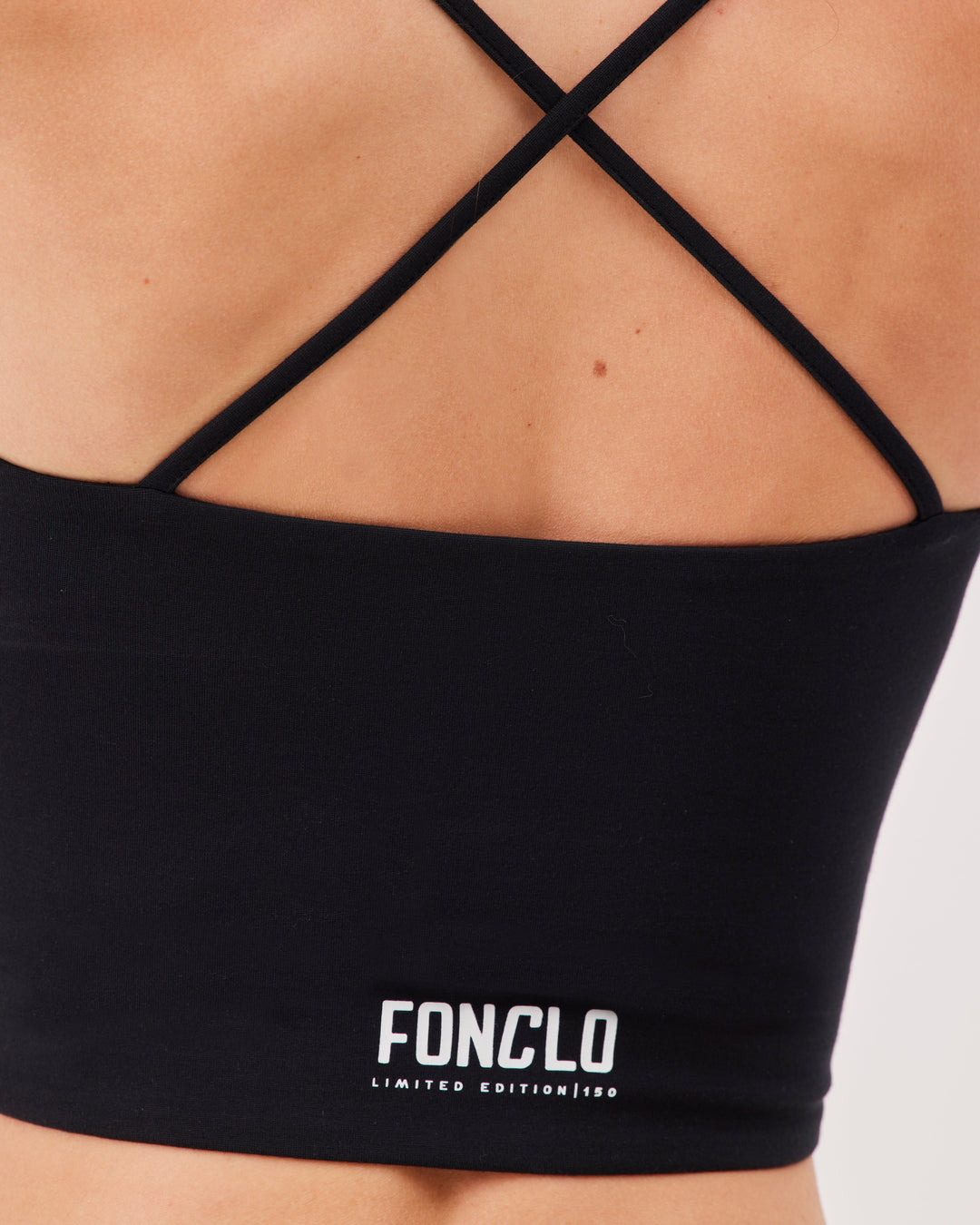 Black criss-cross strap sports bra, V-neckline, crossed straps at the back, fonclo logo on the back, high-quality, super-soft material, crop, strappy, slim fit.