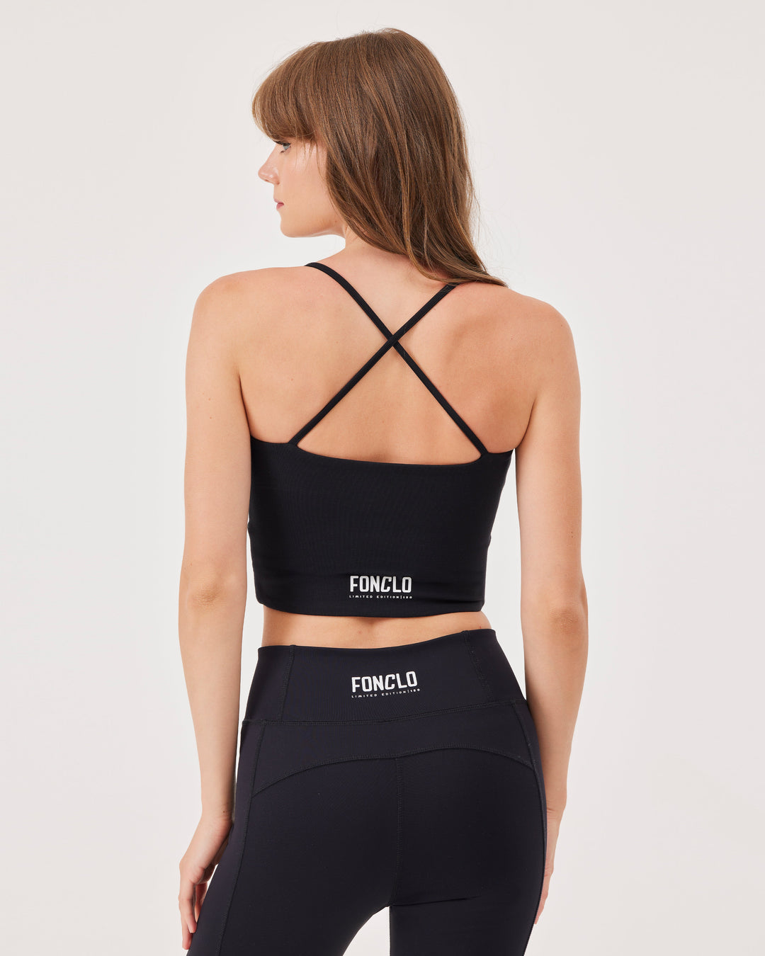 Black criss-cross strap sports bra, V-neckline, crossed straps at the back, fonclo logo on the back, high-quality, super-soft material, crop, strappy, slim fit.