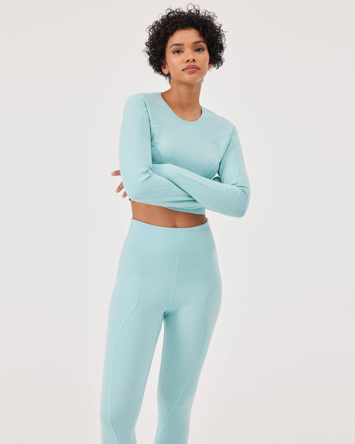 Blue, long sleeved crop top, raglan sleeves, thumb holes, round neck, slim fit, high-quality stretch fabric. 