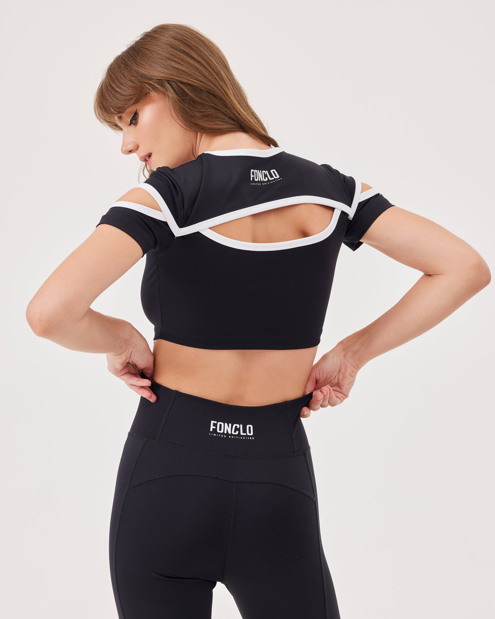 Black cropped top, cut-outs, keyhole neckline in the front and back, round neckline, crop cut contrast stripes, fonclo logo on the back, short sleeves, slim fit.