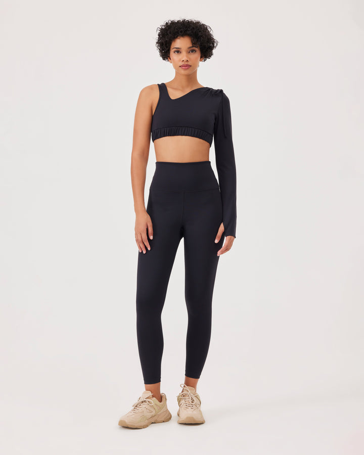 Black asymmetrical cropped top, asymmetrical sleeves, lacing on the shoulder, elastic waistband, slim fit, one long sleeve, thumb hole, sports bra. 