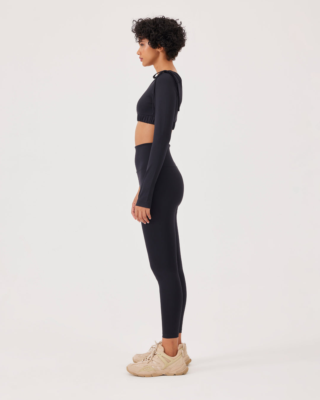 Black asymmetrical cropped top, asymmetrical sleeves, lacing on the shoulder, elastic waistband, slim fit, one long sleeve, thumb hole, sports bra. 