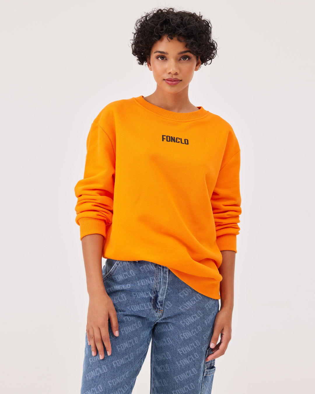 Orange, basic sweatshirt, fonclo logo on the front, long sleeves, dropped shoulders, round neckline. Ribbed cuffs on the sleeves, hem, and neckline, soft material, overBeden.