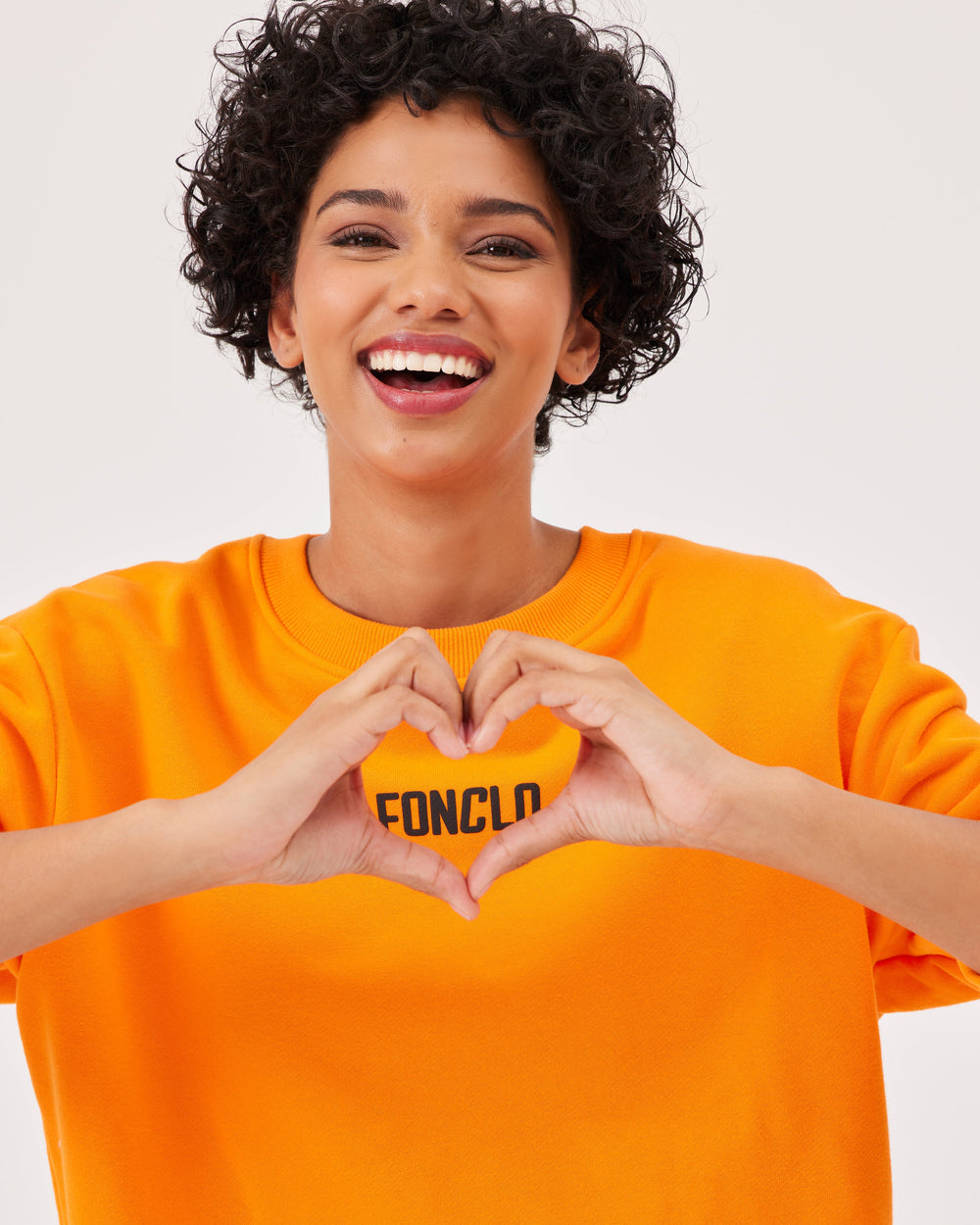 Orange, basic sweatshirt, fonclo logo on the front, long sleeves, dropped shoulders, round neckline. Ribbed cuffs on the sleeves, hem, and neckline, soft material, overBeden.