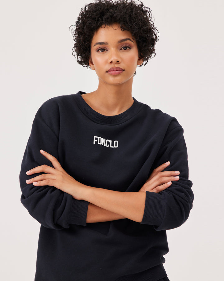 Black basic sweatshirt, with fonclo logo on the front, long sleeves, dropped shoulders, round neckline. Ribbed cuffs on the sleeves, hem, and neckline, soft material, overBeden.