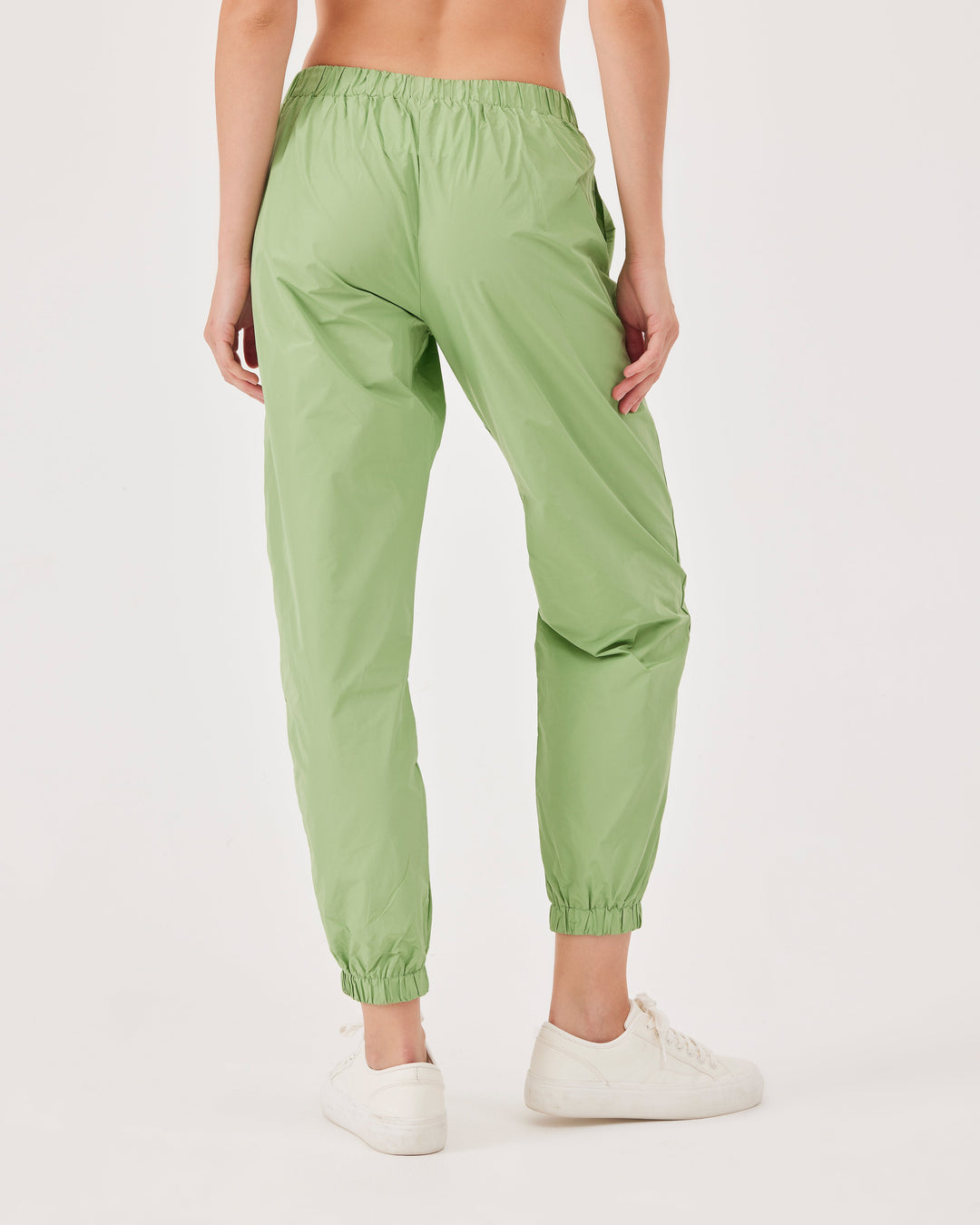 Green, lightweight running joggers, pants, elastic waistband, parachute fabric, ankle-length, regular fit, side pockets.