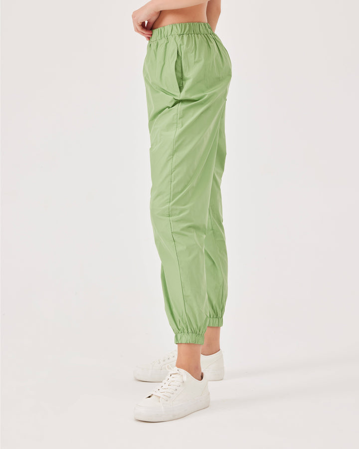 Green, lightweight running joggers, pants, elastic waistband, parachute fabric, ankle-length, regular fit, side pockets.