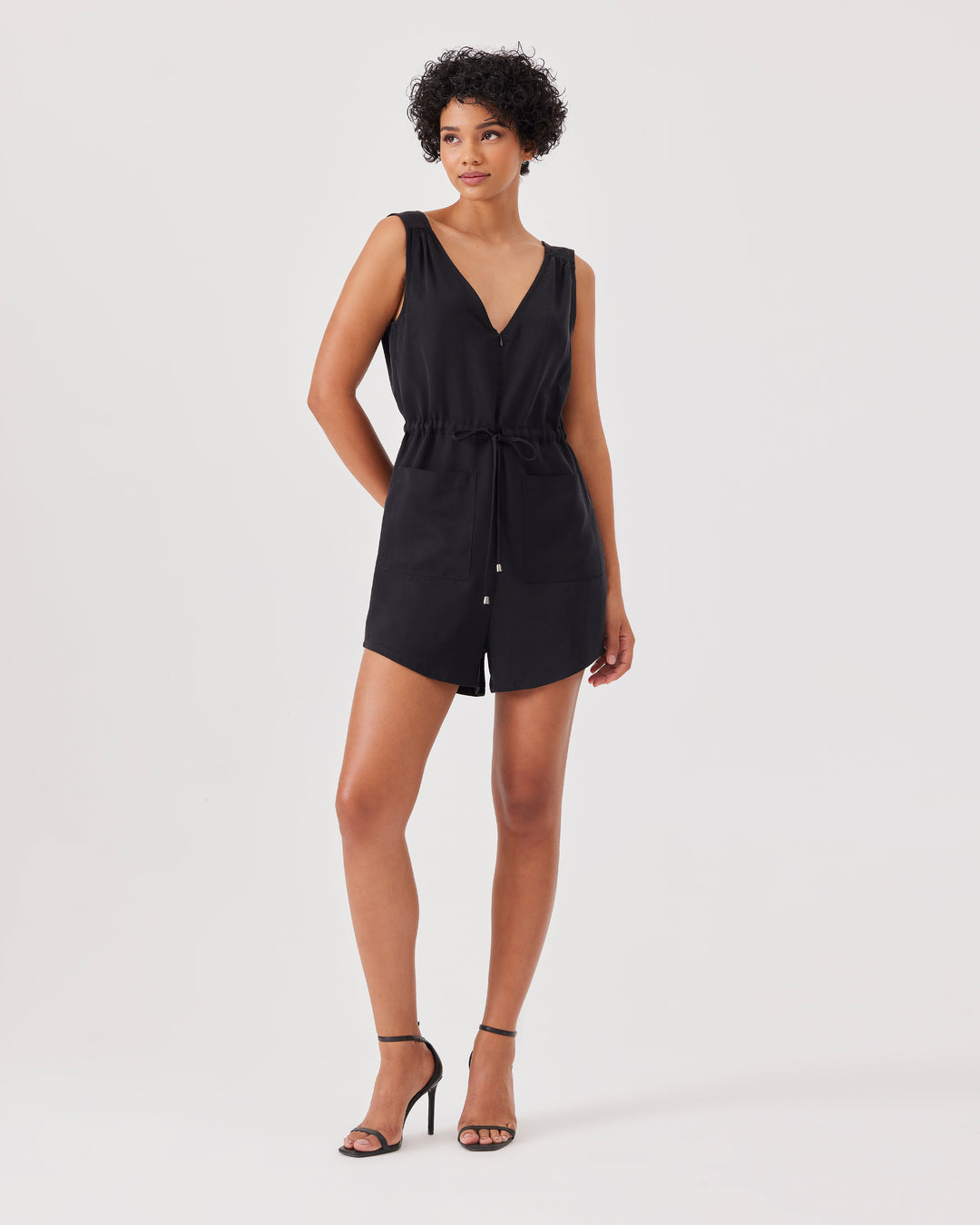 Black, mini, lyocell-blend, jumpsuit, overall, short, sleeveless, v-neck at the front and back, front zipper, drawstring at the waist, front pockets, regular fit. 