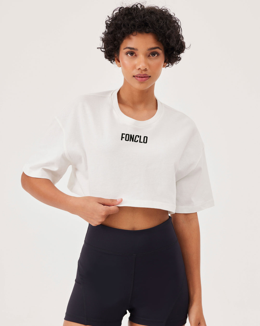 White, cropped t-shirt, short sleeved, front fonclo logo, loose fit, overBeden, round neck. 